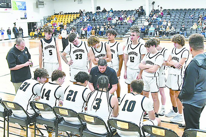 MOUNDS COACH JONATHAN CLAY (center, kneeling) goes over pregame strategy with the Eagles before tipoff on Tuesday night.
