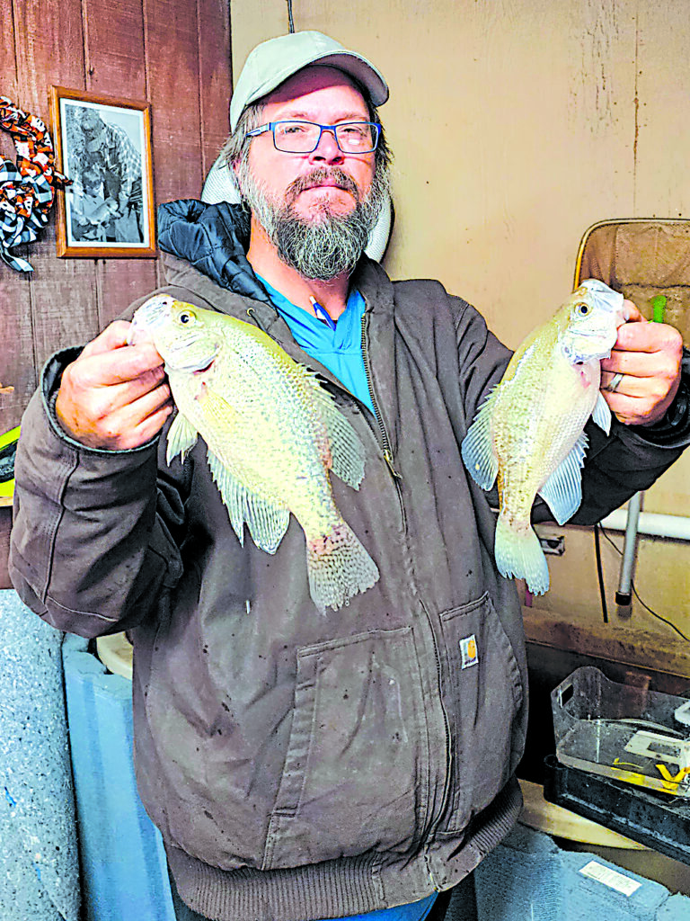 CHARLES BETZLER PHOTOS CONCESSIONAIRE DUSTIN COATS holds two beautiful specimens of white crappie he caught at Sahoma.