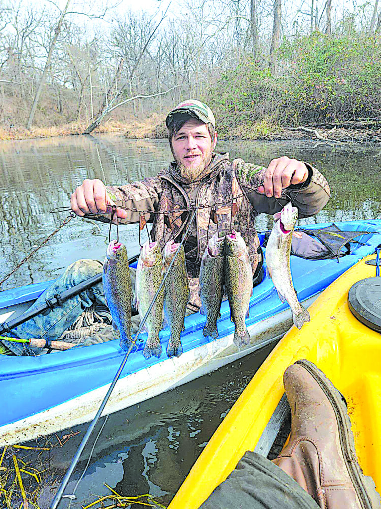 CHARLES BETZLER PHOTOS LOCAL ANGLER holds up a string of rainbow trout that he caught recently
