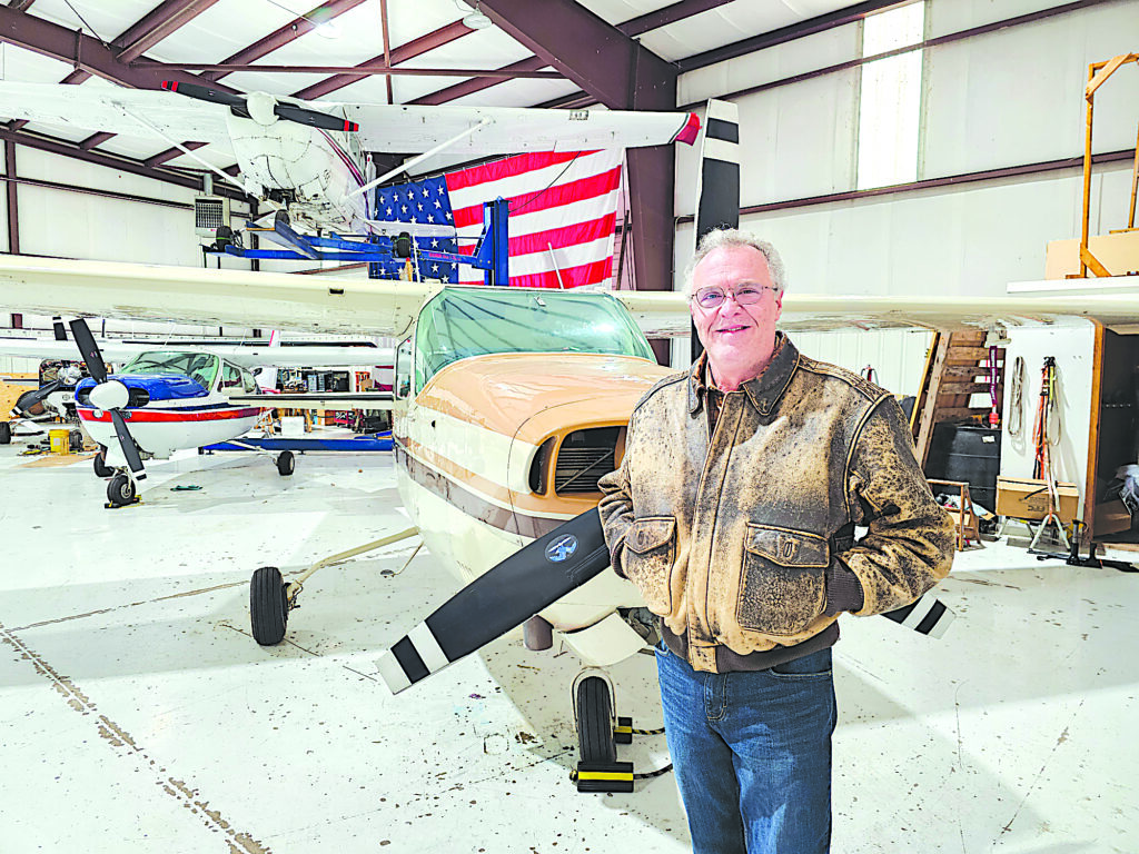 CHARLES BETZLER PHOTOS DAN HOWARD stands in front of an airplane at the hanger.