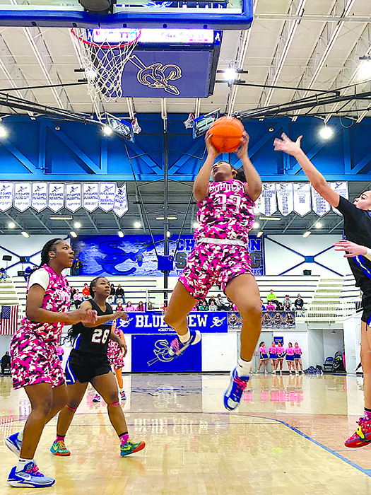 SENIOR TYLA HEARD leaps up to sink a layup, while sophomore Nylia Reid (left) looks on.