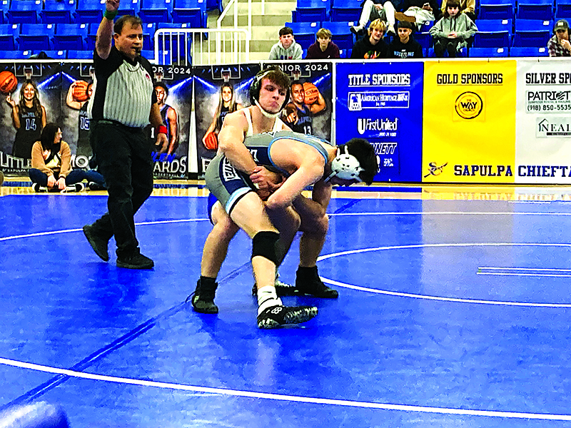 JOHN TRANCHINA PHOTO ALEX HENDERSON, shown here about to take down Enid’s Fortner in the dual on Jan. 4, placed sixth at 144 pounds at Sand Springs