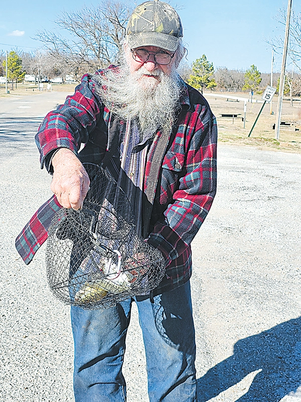 CHARLES BETZLER PHOTO KEITH BROOM, a regular at Sahoma Lake, displays his basket of fish.