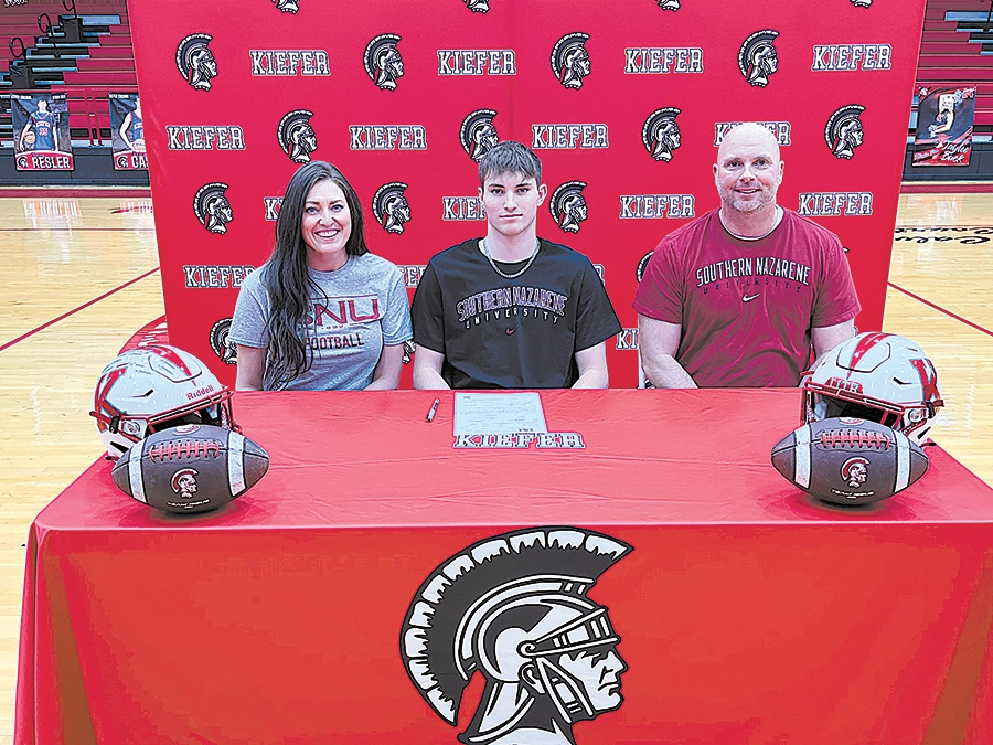 DARREN SUMNER PHOTO KIEFER QUARTERBACK JAXON WORLEY with his parents, Ashlee and Trent, at Wednesday’s signing day ceremony.