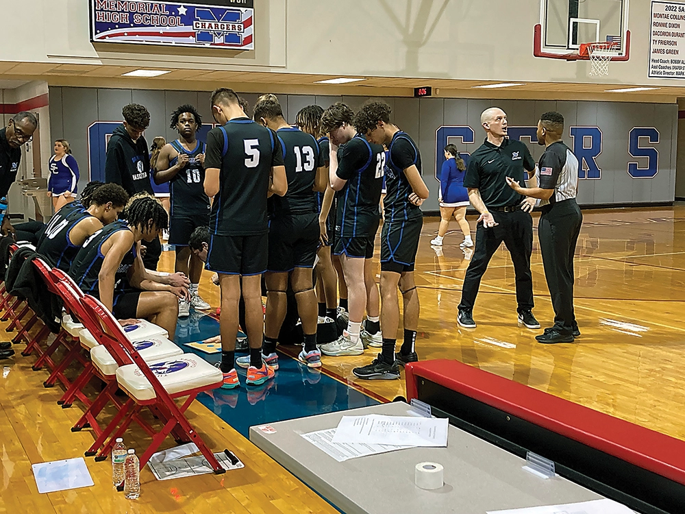 JOHN TRANCHINA PHOTOS SAPULPA COACH JORDAN NAGEL (second from right) has a calm discussion with the official while assistant coach Landon Stewart (kneeling in middle) designs a play during a timeout Tuesday night.