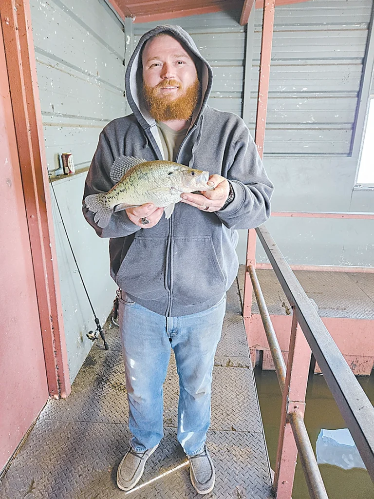 CHARLES BETZLER PHOTOS Michael Bishop proudly displays a large crappie he caught at the indoor fishing dock at Lake Sahoma on Wednesday.