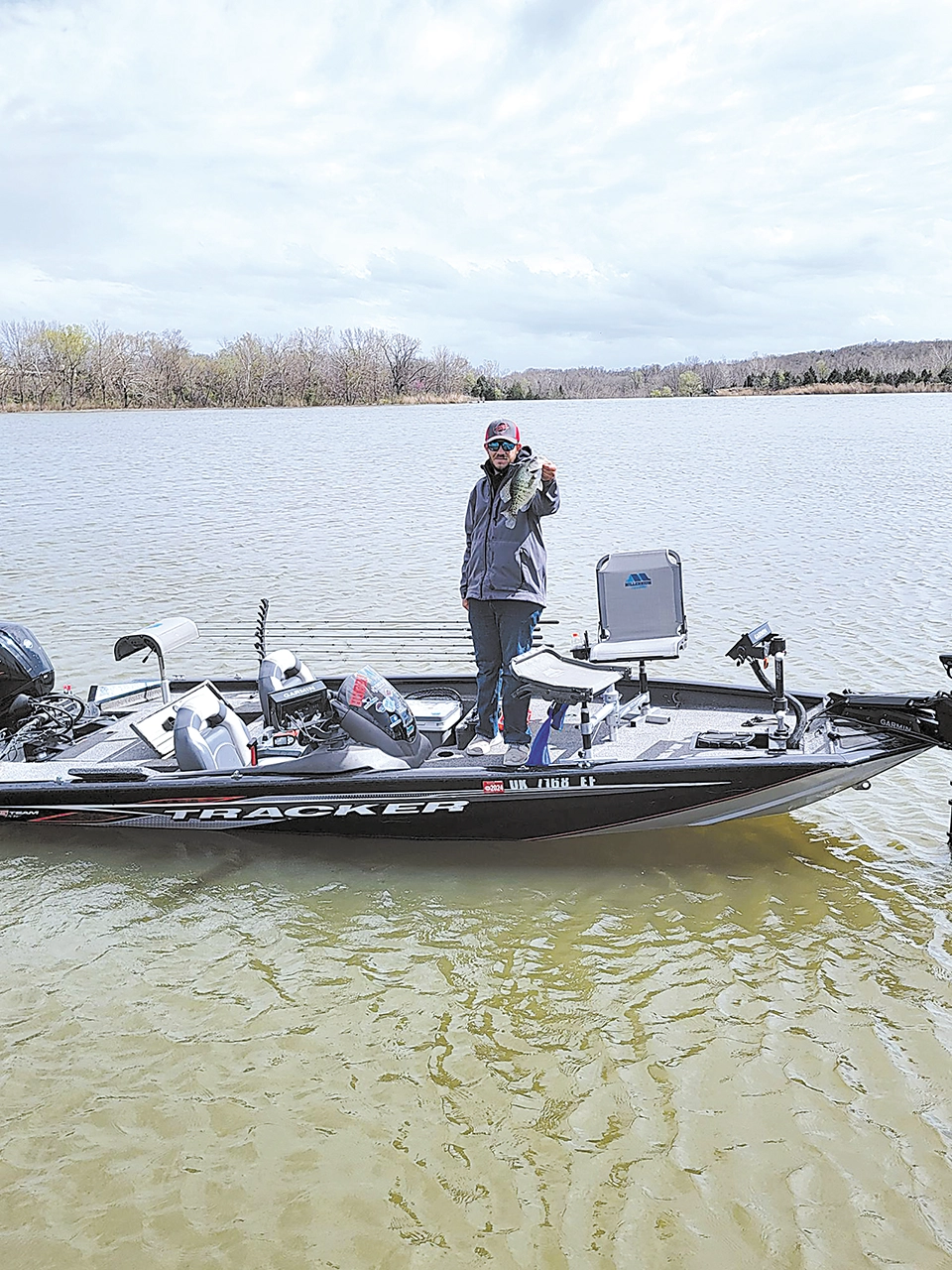 CHARLES BETZLER PHOTOS LOCAL FISHERMAN proudly display the crappie he caught at Sahoma Lake this week.