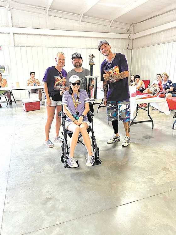 MADISON KING (in wheelchair) celebrates her win of the Mayors Choice Award for her purple
and white Ford Bronco at the Route 66 Merica Fest Car Show.