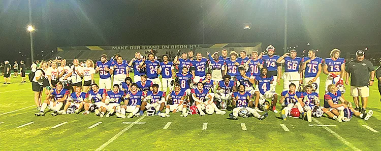 THE VICTORIOUS EAST TEAM following their 14-6 victory over the West Friday night at OBU, featuring Sapulpa players Kylar Bearpaw (left side, standing, No. 72) and Marco Smith (sitting, No. 26), as well as Kiefer’s Jaxon Worley (center, sitting, No. 18).