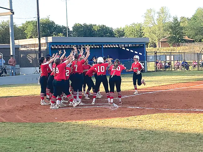 JOHN TRANCHINA Photos ALL HAIL KAMMIE! Lady Trojan senior Kammie Smith (right, 9) trots home after the first of her two home runs Monday night, while her teammates wait for her, celebrating at home plate. Smith hit another bomb two innings later and ended up 4-for-4 with five RBIs in the 6-1 victory.