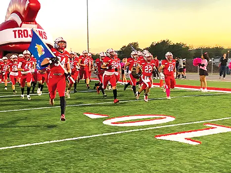 KIEFER TROJANS were ready to play Thursday night against Hugo. Leading the squad out of
the inflatable helmet before their impressive 30-28 comeback victory was senior Brayden Holt
(34) carrying the flag.