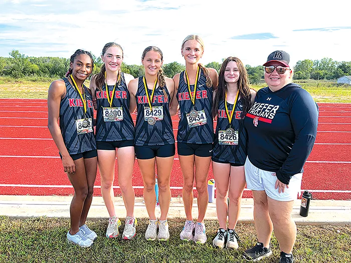 SUBMITTED PHOTOS LADY TROJAN CHAMPIONS Kiefer’s girls won the team competition at Oilton on Saturday, thanks to posting four of the top six runners and five medalists. From left to right: Channing Hallum, Callie Hutchison, Hanna Hendrix, Coley Rowton, Lynlee Anderson and Coach NaDenna LaVarnway.