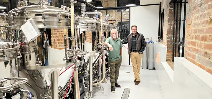 RANDY CALLEY (right) and JIM DILLEY pose next to their unique brewing vessels.