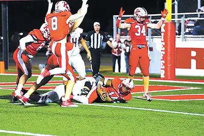 TOUCHDOWN! Kiefer’s Dezmond Nash (14, on ground) scores a touchdown Friday night as
teammates Brayden Holt (34) and Cameron Bowman (8) celebrate. The Trojans play in the 2AI
quarterfinals.