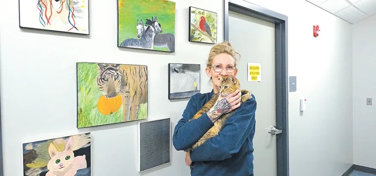 CHARLES BETZLER PHOTO
SAPULPA ANIMAL Shelter Director Brandie Willard holds Tanya, an adorable domestic short
hair cat that is available for adoption. The paintings in the background are donated by local artist
James Herron. A free painting of your choice comes with each pet adopted.